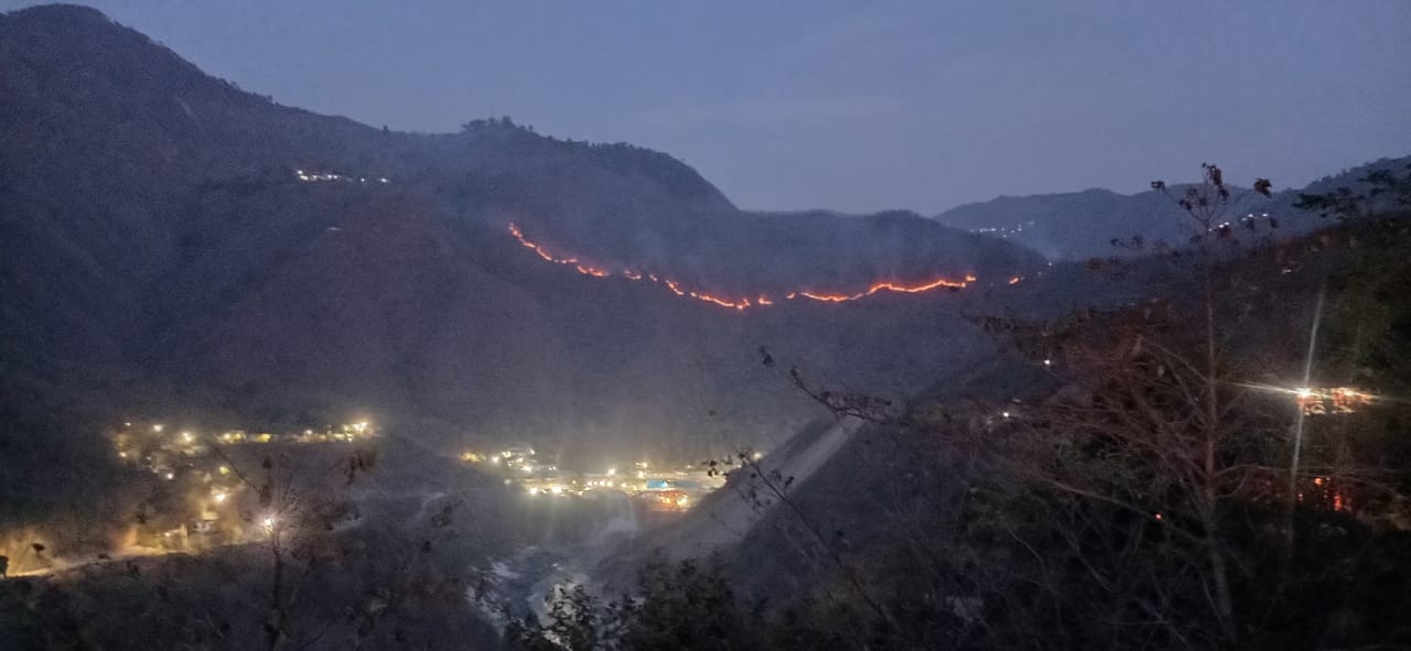 फोटो कैप्शन-28एनटीएच1- देवप्रयाग के सौड़ गांव स्थित रेलवे परियोजना के निकट जंगलों में लगी आग।  