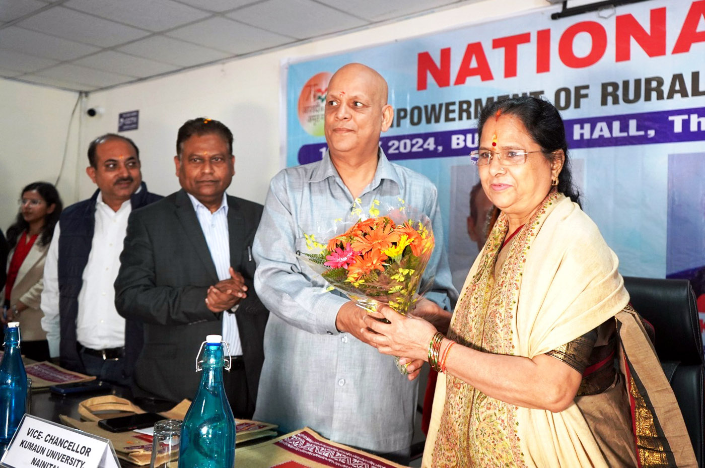 मुख्य अतिथि राज्य महिला आयोग की अध्यक्ष कुसुम कंडवाल का संगोष्ठी में अभिनंदन करते संगोष्ठी संयोजक।