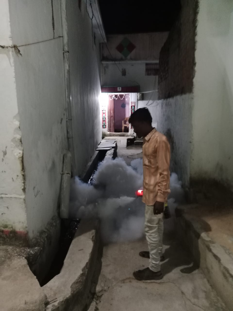 वार्ड में दवा का छिड़काव करता हुआ कर्मचारी।