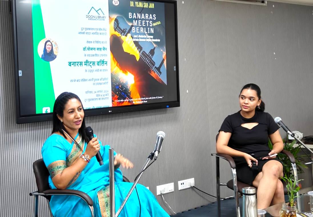दून पुस्तकालय में 'बनारस मीट्स बर्लिन' पुस्तक के विविध पक्षों पर बतातीं लेखिका डॉ. योजना साह जैन (साड़ी में)। दून पुस्तकालय में 'बनारस मीट्स बर्लिन' पुस्तक के विविध पक्षों पर बतातीं लेखिका डॉ. योजना साह जैन (साड़ी में)।