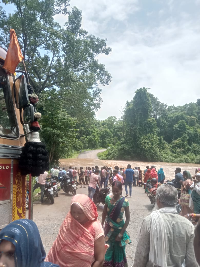 नदी में बाढ़ आने के कारण नदी किनारे खड़े हुए लोग। नदी में बाढ़ आने के कारण नदी किनारे खड़े हुए लोग।