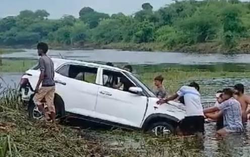 बांध के पानी से कार को बाहर निकालते ग्रामीण बांध के पानी से कार को बाहर निकालते ग्रामीण