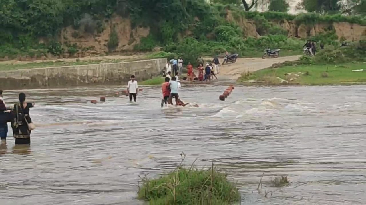 वृद्धा को बचाते ग्रामीण्ण वृद्धा को बचाते ग्रामीण्ण
