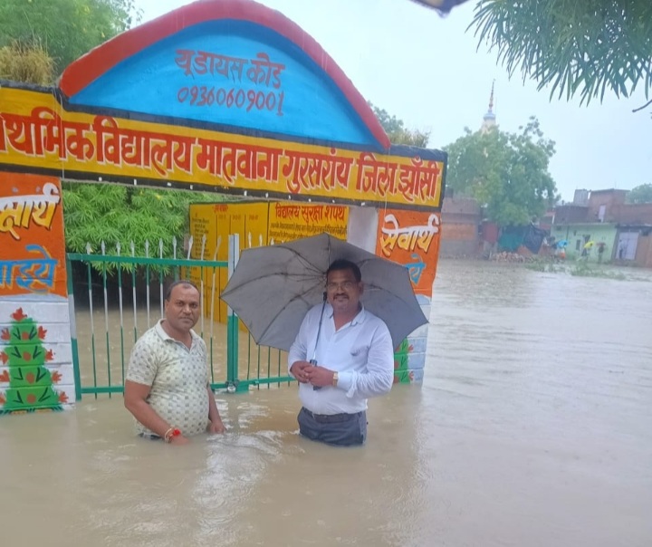 स्कूल के बाहर छाते में कमर तक पानी देख अचंभित शिक्षक स्कूल के बाहर छाते में कमर तक पानी देख अचंभित शिक्षक