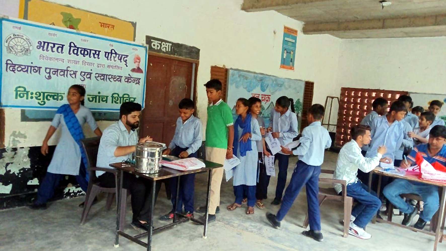 निशुल्क चिकित्सा शिविर में नेत्र जांच करते चिकित्सक।