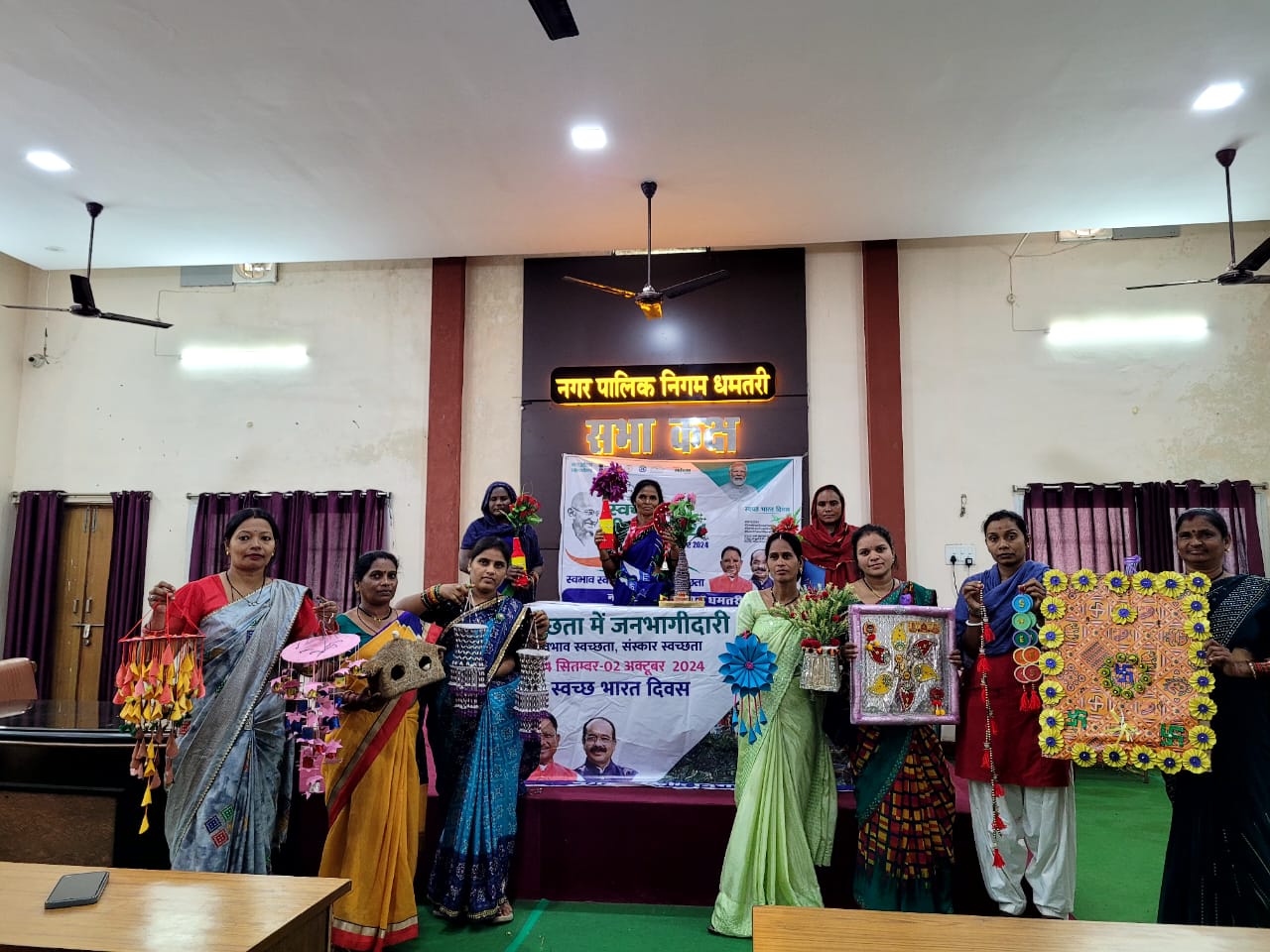 कचरों से बनाई आकर्षक कलाकृति दिखाती हुई स्वच्छता कार्यक्रम से जुड़ी हुई स्वच्छता दीदी। कचरों से बनाई आकर्षक कलाकृति दिखाती हुई स्वच्छता कार्यक्रम से जुड़ी हुई स्वच्छता दीदी।