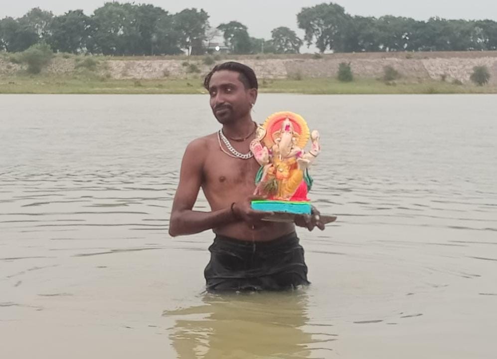 महानदी में भगवान गणेश की मूर्ति को विसर्जित करते हुए भक्त। महानदी में भगवान गणेश की मूर्ति को विसर्जित करते हुए भक्त।