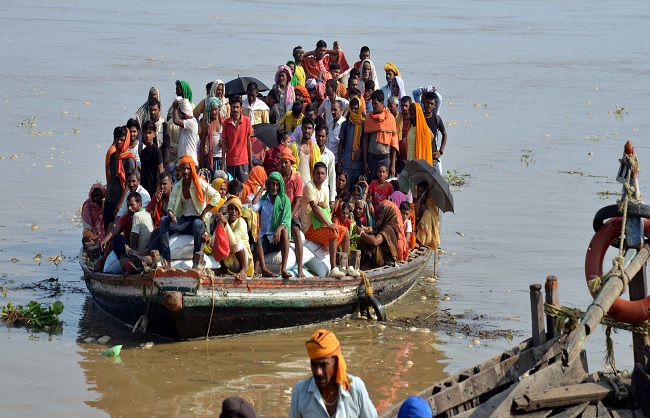 बाढ़ प्रभावित लोग नाव से सुरक्षित स्थान की ओर जाते हुए बाढ़ प्रभावित लोग नाव से सुरक्षित स्थान की ओर जाते हुए