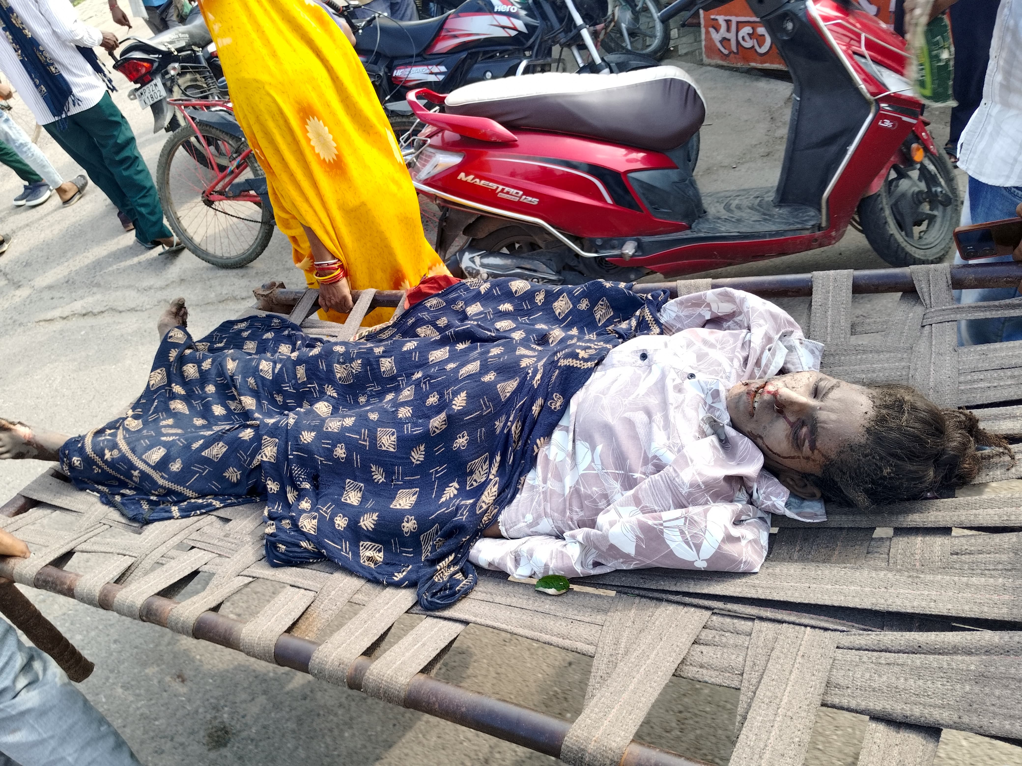 घायलों को निकालकर चारपाई पर लेकर जाते लोग घायलों को निकालकर चारपाई पर लेकर जाते लोग