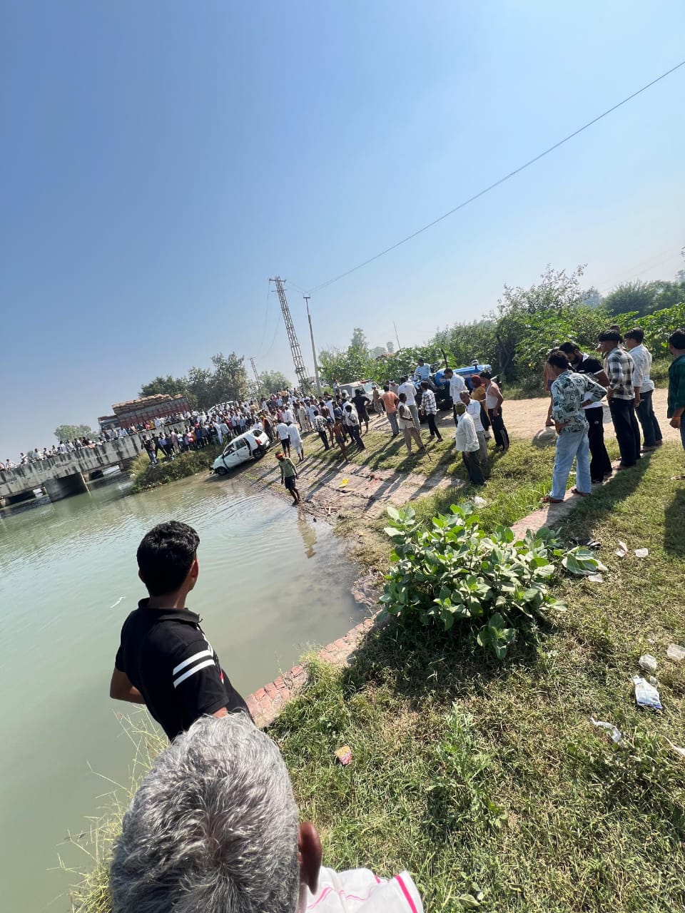 कार के नहर में गिरने के बाद जमा हुए ग्रामीण व बाहर निकल गई कर कार के नहर में गिरने के बाद जमा हुए ग्रामीण व बाहर निकल गई कर