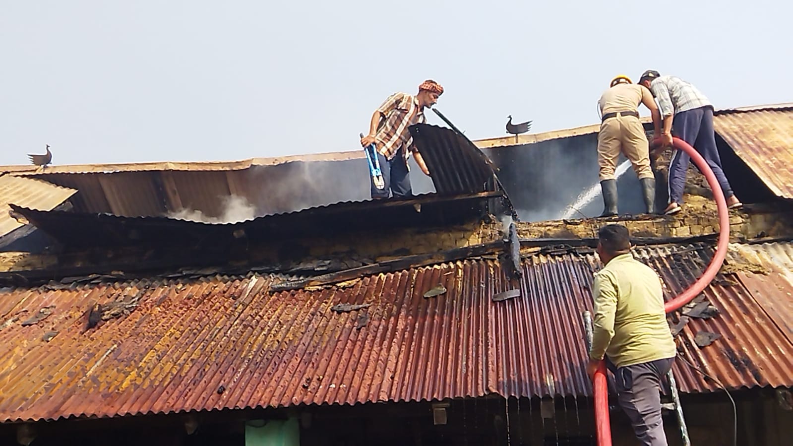 आग बुझाते कर्मचारी। आग बुझाते कर्मचारी।