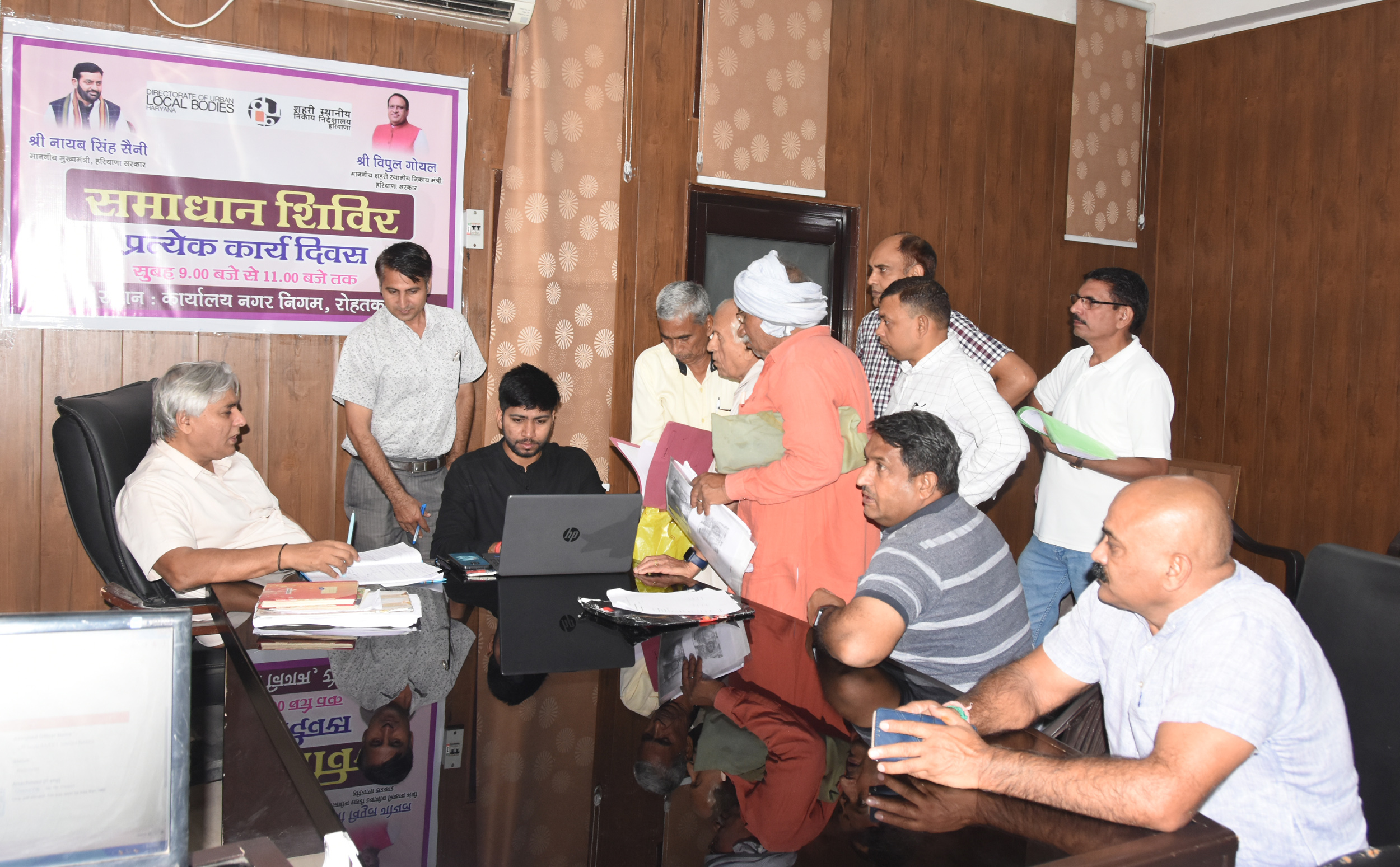 फोटो कैप्शनः 24 आरटीकेः1  समाधान शिविर में लोगों की समस्याएं सुनते अधिकारी।