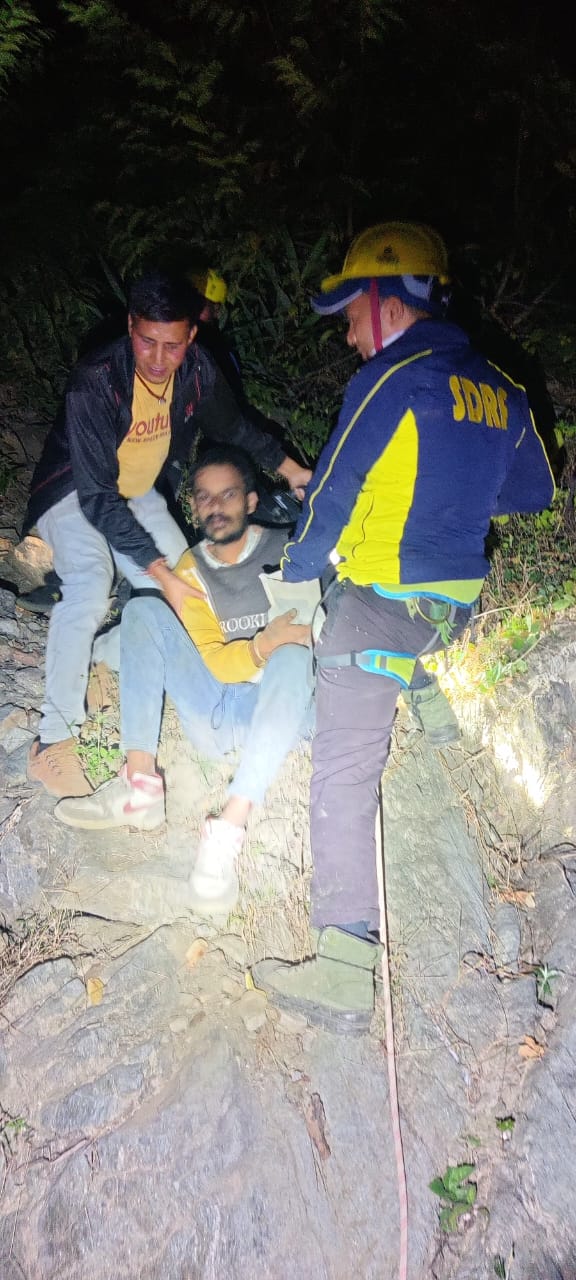 खाई में गिरे युवक को निकालते एसडीआरएफ जवान। खाई में गिरे युवक को निकालते एसडीआरएफ जवान।