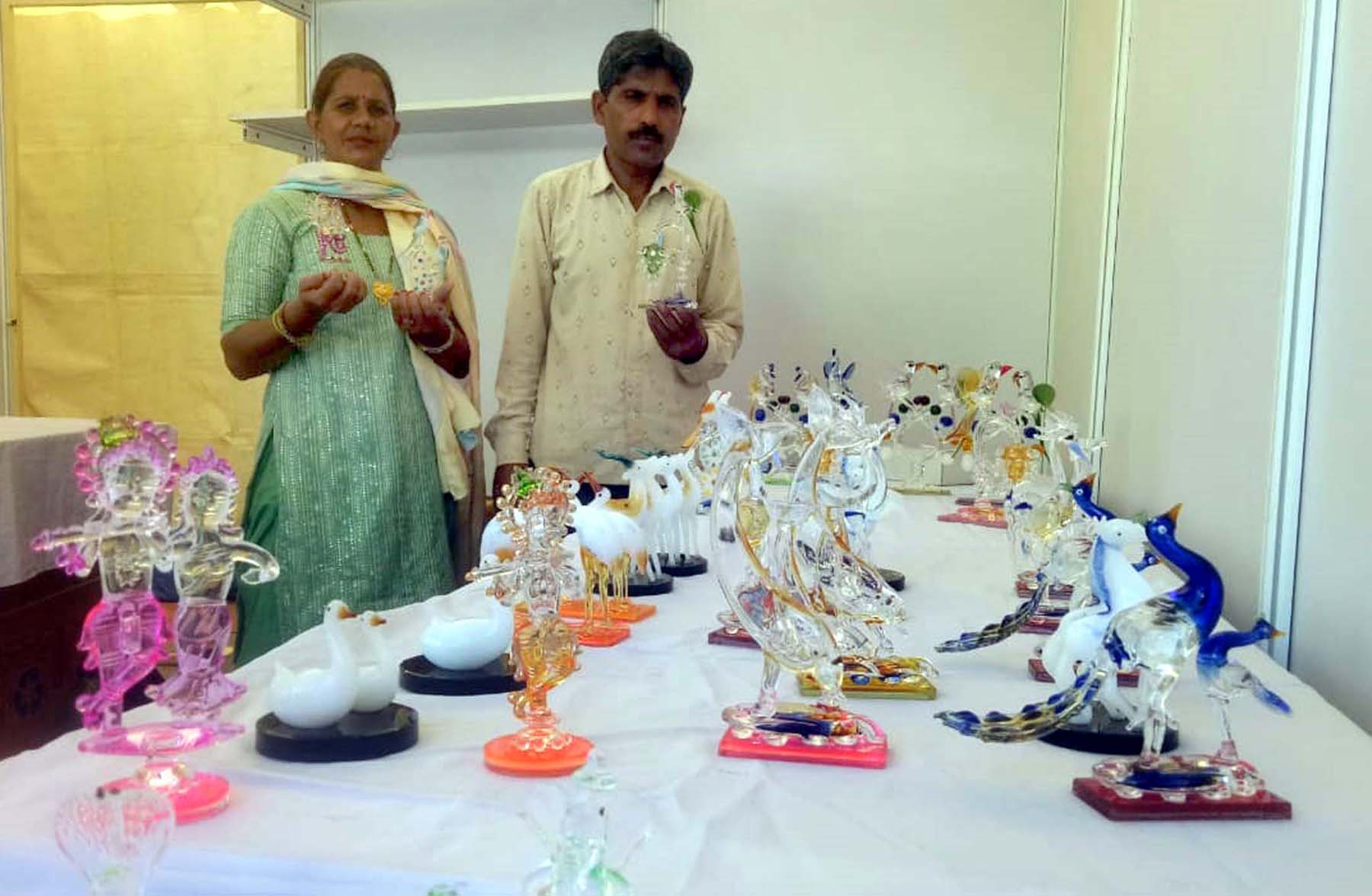 फोटो नंबर-05: गुरुग्राम के सेक्टर-29 स्थित सरस मेले में क्रिस्टल के आइटम दिखाते दंपत्ति।