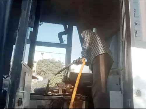 बस में लगी आग बुझाता फायर ब्रिगेड का कर्मचारी। बस में लगी आग बुझाता फायर ब्रिगेड का कर्मचारी।