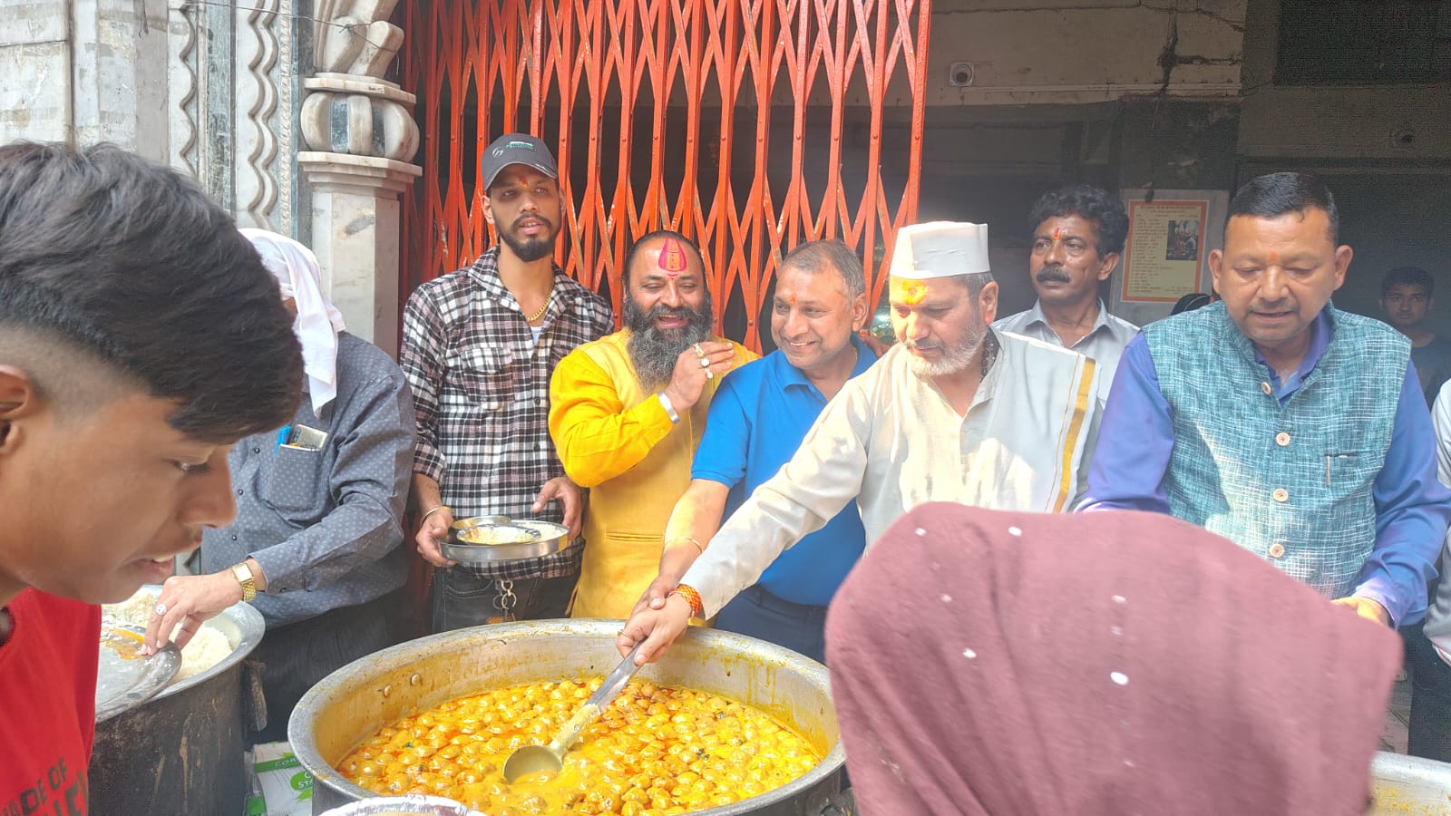 गोवर्धन पूजा पर प्रसाद वितरण करते पंडित उदयशंकर भट्ट व अन्य। गोवर्धन पूजा पर प्रसाद वितरण करते पंडित उदयशंकर भट्ट व अन्य।