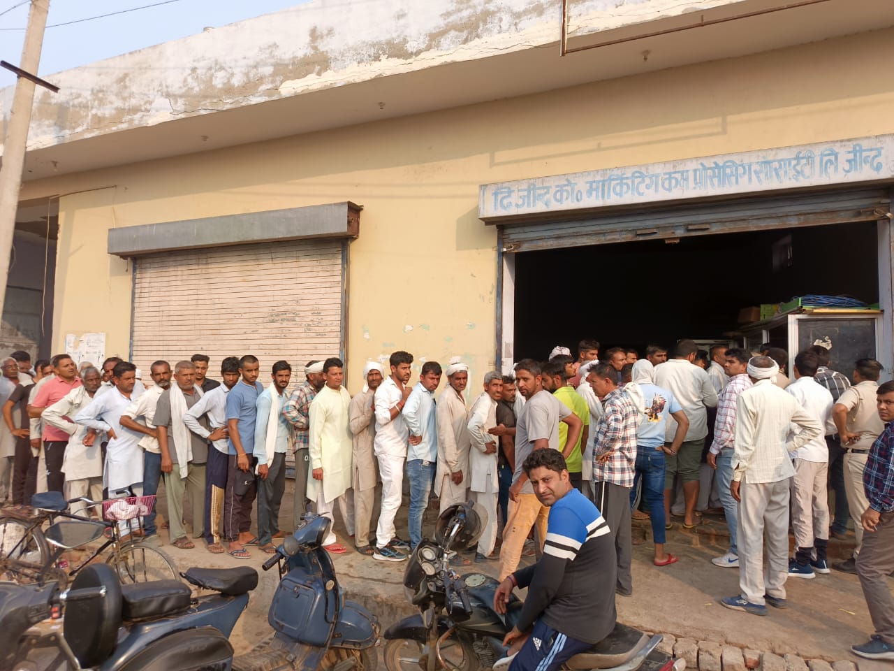 सरकारी खाद की दुकान पर लगी लंबी कतारें। सरकारी खाद की दुकान पर लगी लंबी कतारें।