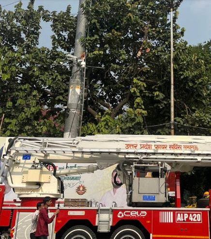 युवक को उतारने का प्रयास करते फायरकर्मी युवक को उतारने का प्रयास करते फायरकर्मी