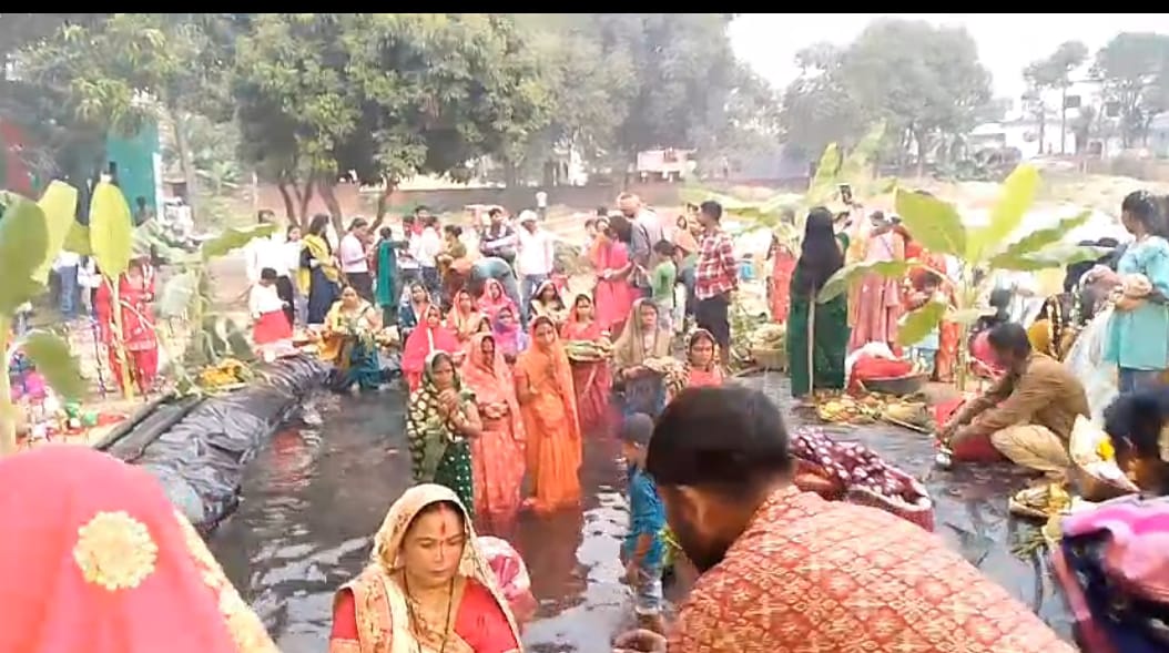 भगवान सूर्य को अर्घ्य देने के लिए पानी में खड़ीं व्रती महिलाएं।