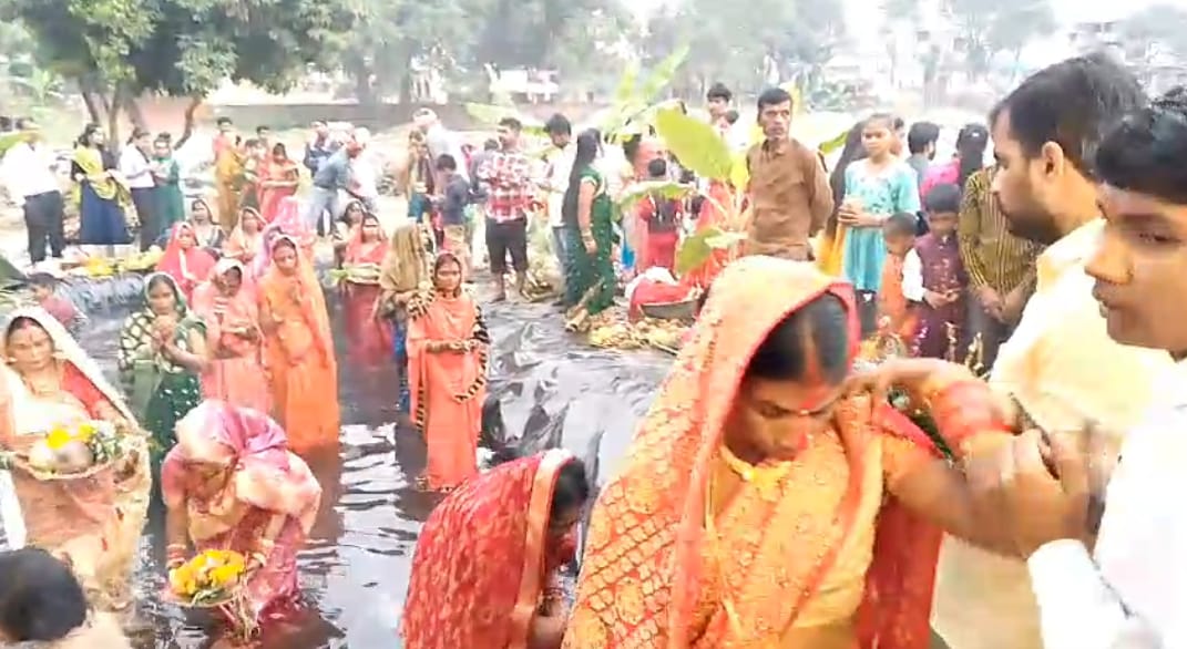 भगवान सूर्य को अर्घ्य देने के लिए पानी में खड़ीं व्रती महिलाएं।