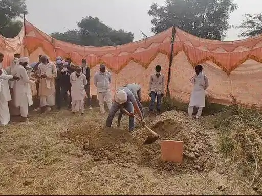 कब्र से मिट्टी हटाते लोग। कब्र से मिट्टी हटाते लोग।