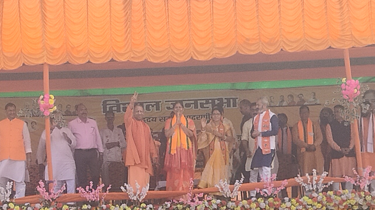 मंच से सभा मे आए लोगों का अभिवादन करते योगी, साथ मे निरसा प्रत्यासी अपर्णा सेन गुप्ता मंच से सभा मे आए लोगों का अभिवादन करते योगी, साथ मे निरसा प्रत्यासी अपर्णा सेन गुप्ता