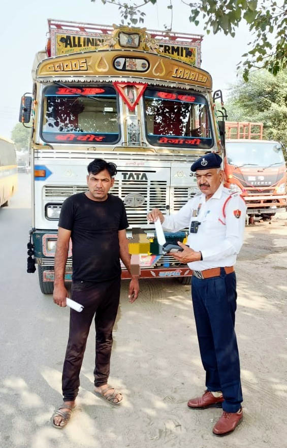 पुलिस कर्मचारी वाहनों के चालान काटते हुए। पुलिस कर्मचारी वाहनों के चालान काटते हुए।