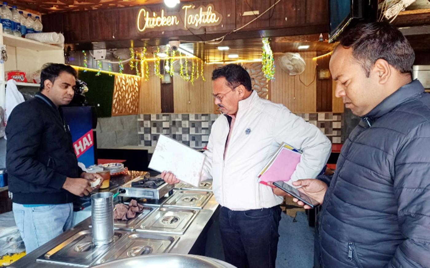 एक प्रतिष्ठान में जांच करते प्रशासनिक अधिकारी। एक प्रतिष्ठान में जांच करते प्रशासनिक अधिकारी।
