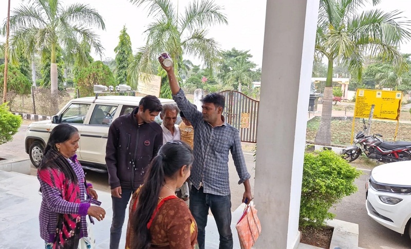 परिवार पर मिट्टी का तेल डालते हुए युवक परिवार पर मिट्टी का तेल डालते हुए युवक