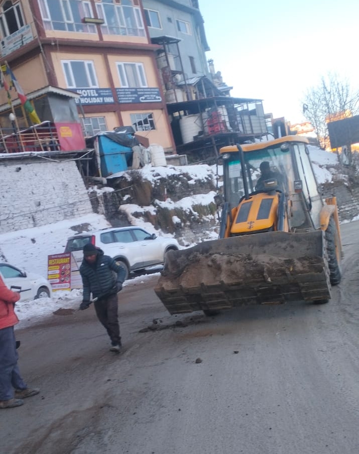 बर्फ़बारी को हटाते लोकनिर्माण विभाग के कर्मी