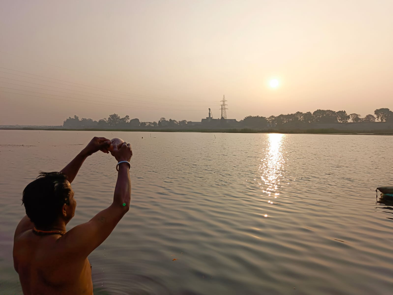 महानदी में खड़े होकर सूर्य को अर्ध्य देता हुआ युवक। महानदी में खड़े होकर सूर्य को अर्ध्य देता हुआ युवक।