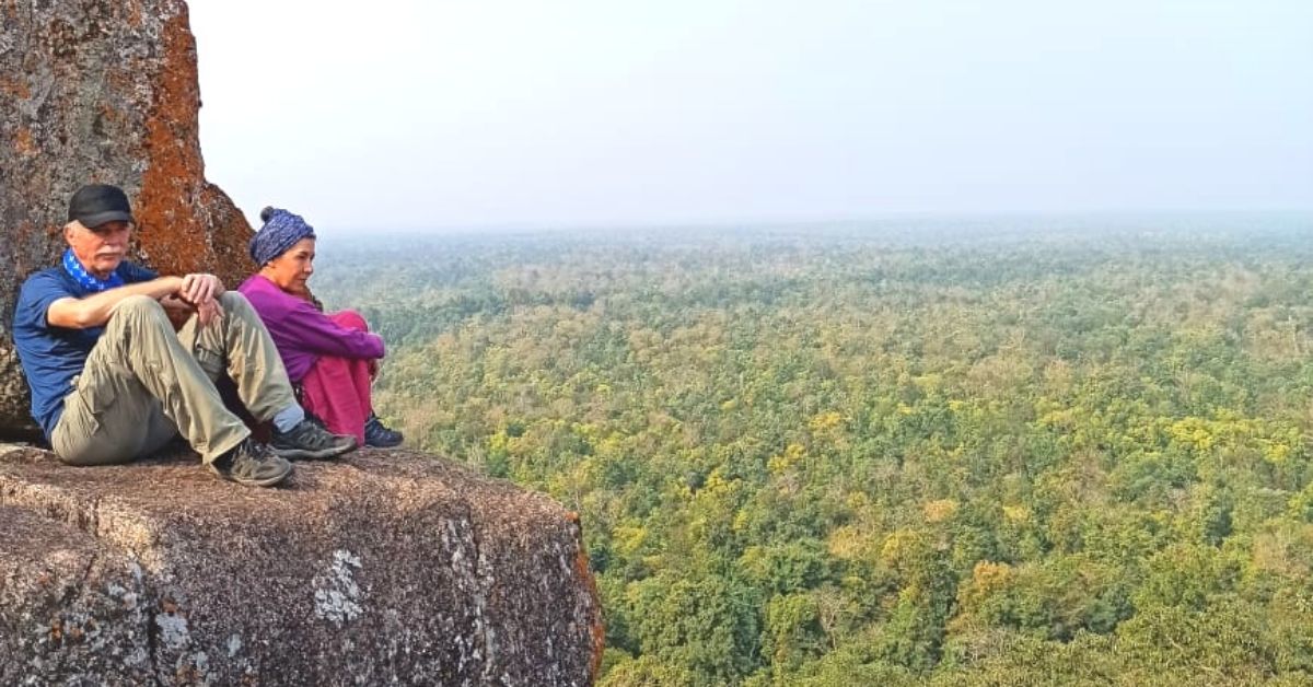 पहाड़ी के छोर में बैठे हुए विदेशी पर्यटक। पहाड़ी के छोर में बैठे हुए विदेशी पर्यटक।