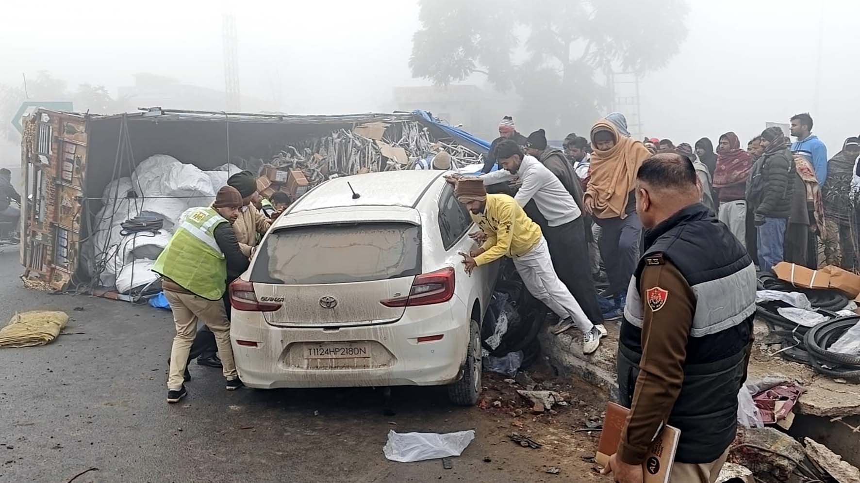 सबसे पहले डिवाइडर से टकराकर पलटी कार को सीधा करते लोग। सबसे पहले डिवाइडर से टकराकर पलटी कार को सीधा करते लोग।