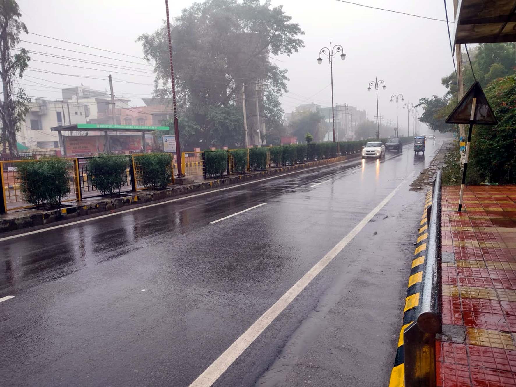बूंदाबांदी के बीच राजगढ़ रोड से गुजरते वाहन। बूंदाबांदी के बीच राजगढ़ रोड से गुजरते वाहन।