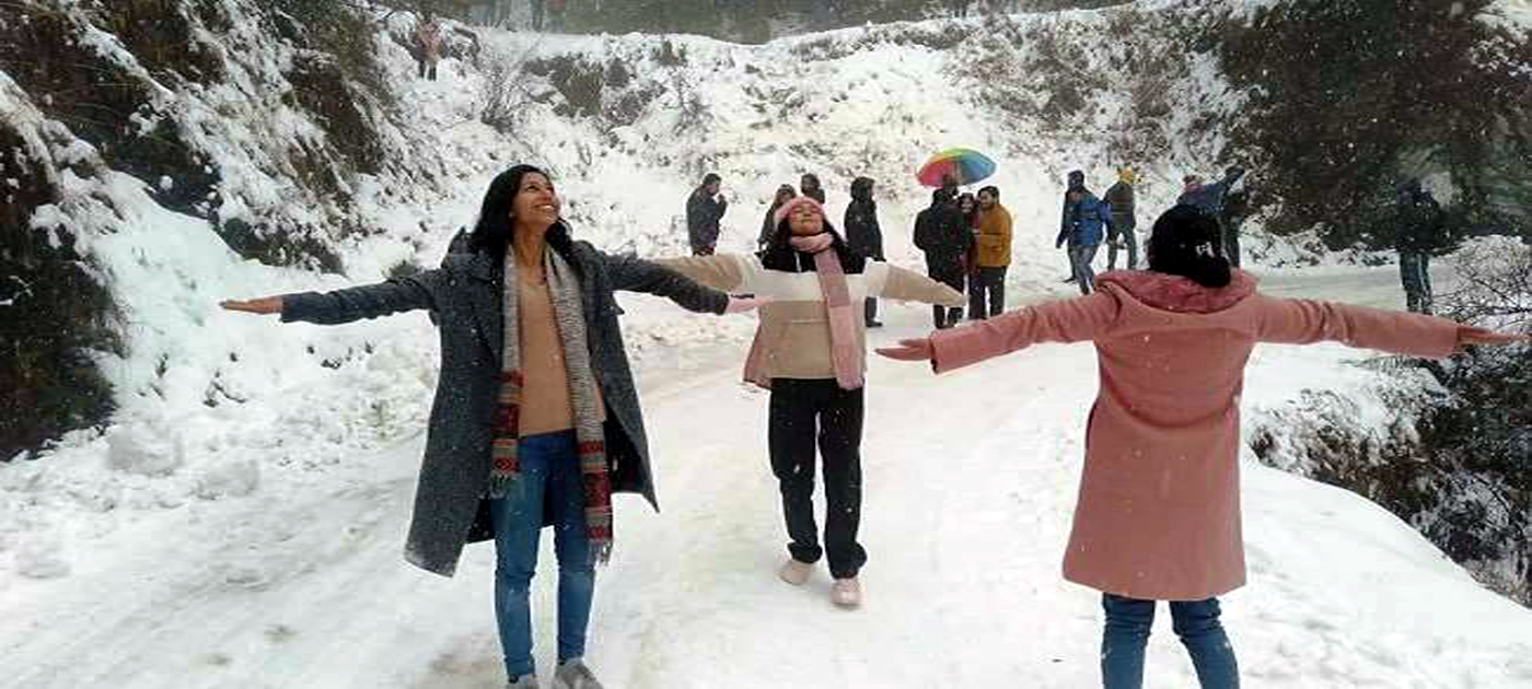 हिमालय दर्शन के पास बर्फ में खेलते-आनंद लेते सैलानी।