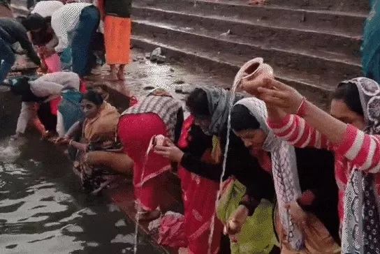 नर्मदापुरम के सेठानी घाट पर स्नान करने के बाद जल चढ़ाती महिलाएं।