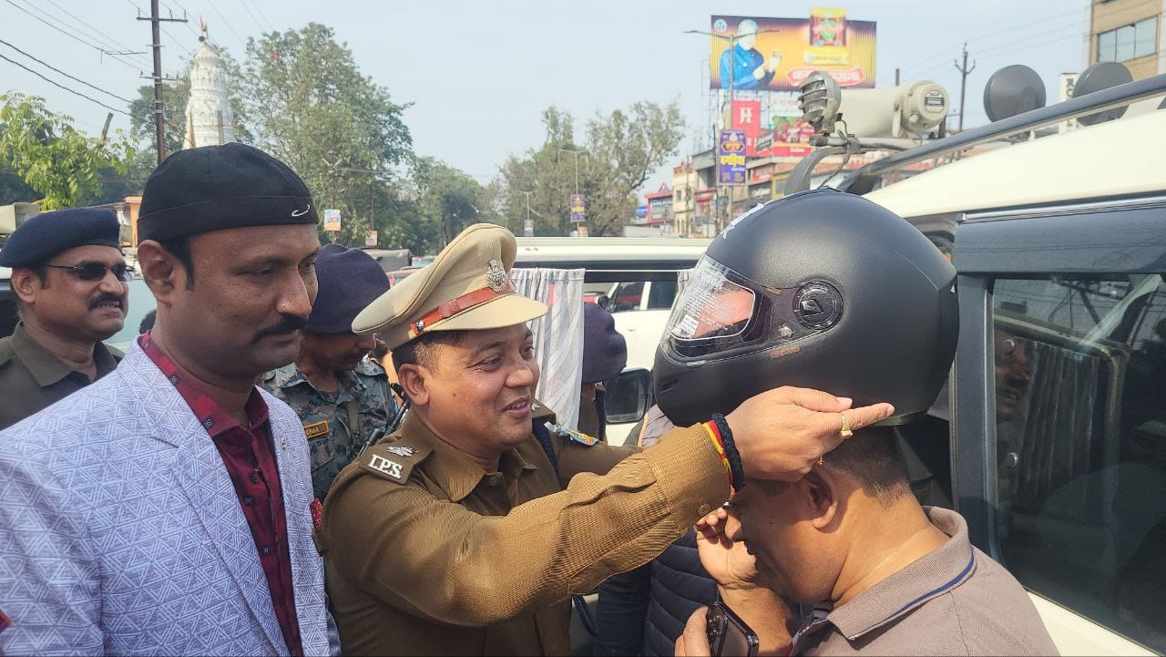 हेलमेट पहनाते अधिकारी हेलमेट पहनाते अधिकारी