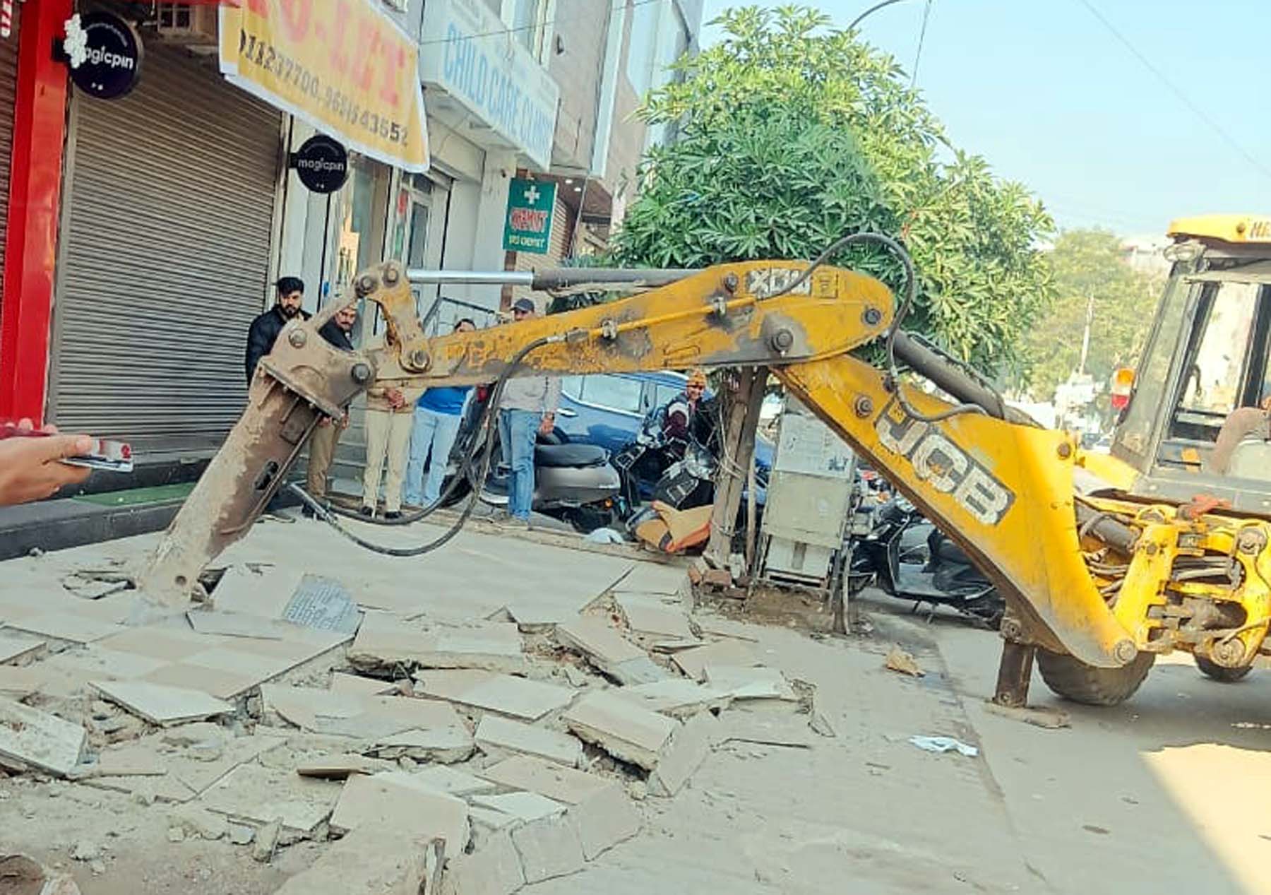 फोटो नंबर-02: गुरुग्राम की न्यू कालोनी में दुकानों के आगे रैंप तोड़ती निगम की जेसीबी। फोटो नंबर-02: गुरुग्राम की न्यू कालोनी में दुकानों के आगे रैंप तोड़ती निगम की जेसीबी।