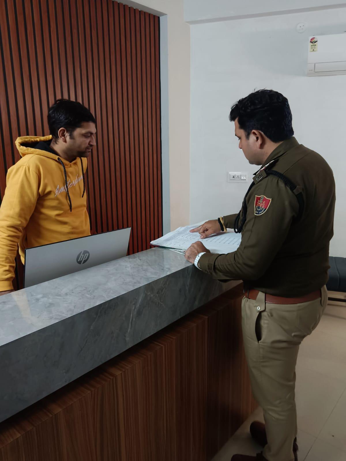 होटल के विजिटर रजिस्टर की जांच करते हुए पुलिसकर्मी। होटल के विजिटर रजिस्टर की जांच करते हुए पुलिसकर्मी।