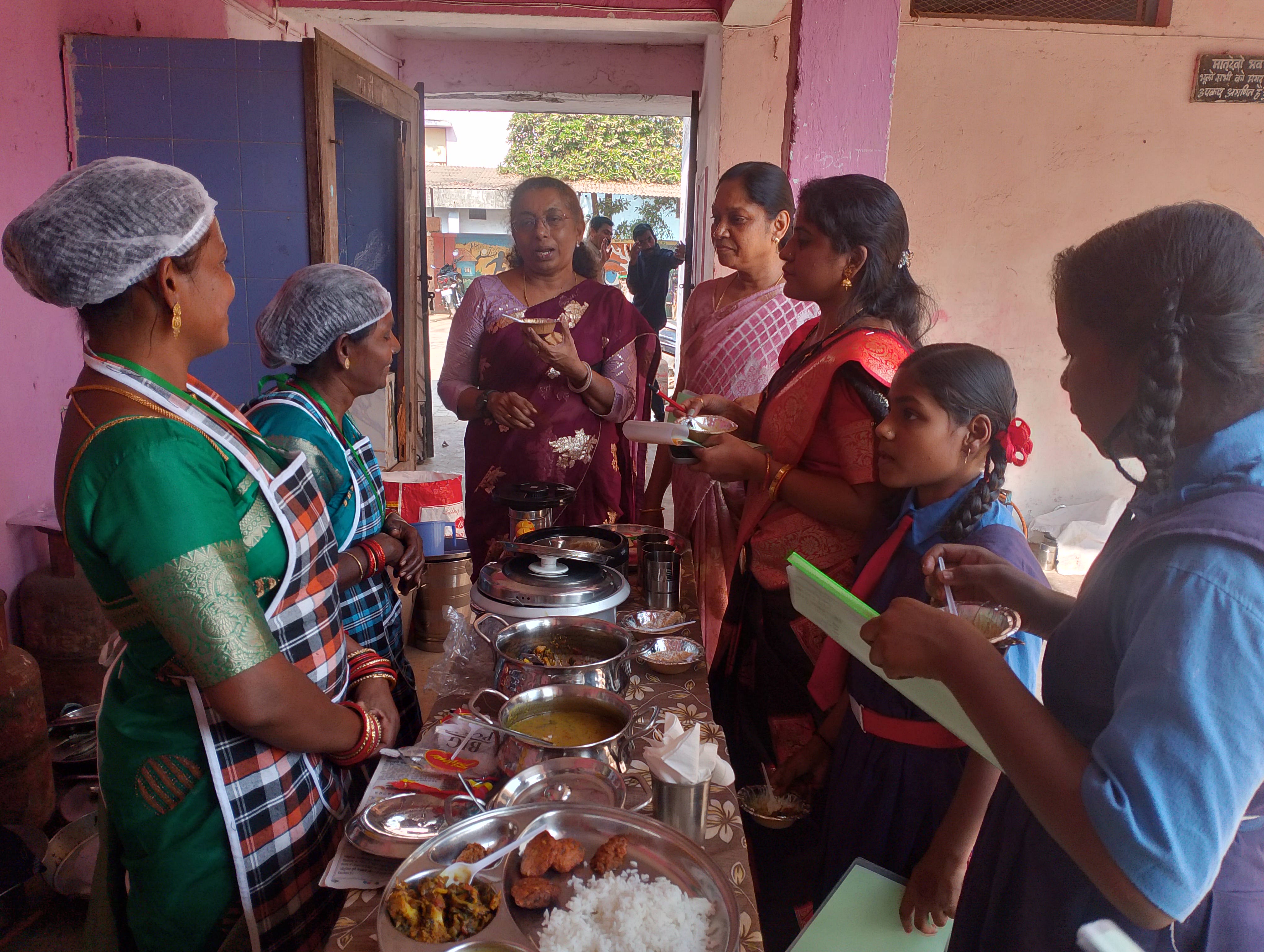 रसोईया, सहायिका एवं संचालकर्ता समूहों द्वारा तैयार व्यंजन का निरीक्षण करते हुए निर्णायक।