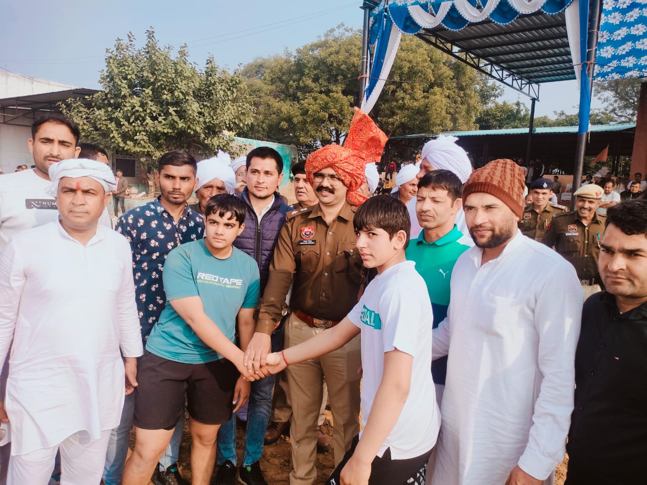 दो बाल पहलवानों के हाथ मिलवा कर कुश्ती आरंभ करवाते डीपी मयंक मिश्रा दो बाल पहलवानों के हाथ मिलवा कर कुश्ती आरंभ करवाते डीपी मयंक मिश्रा