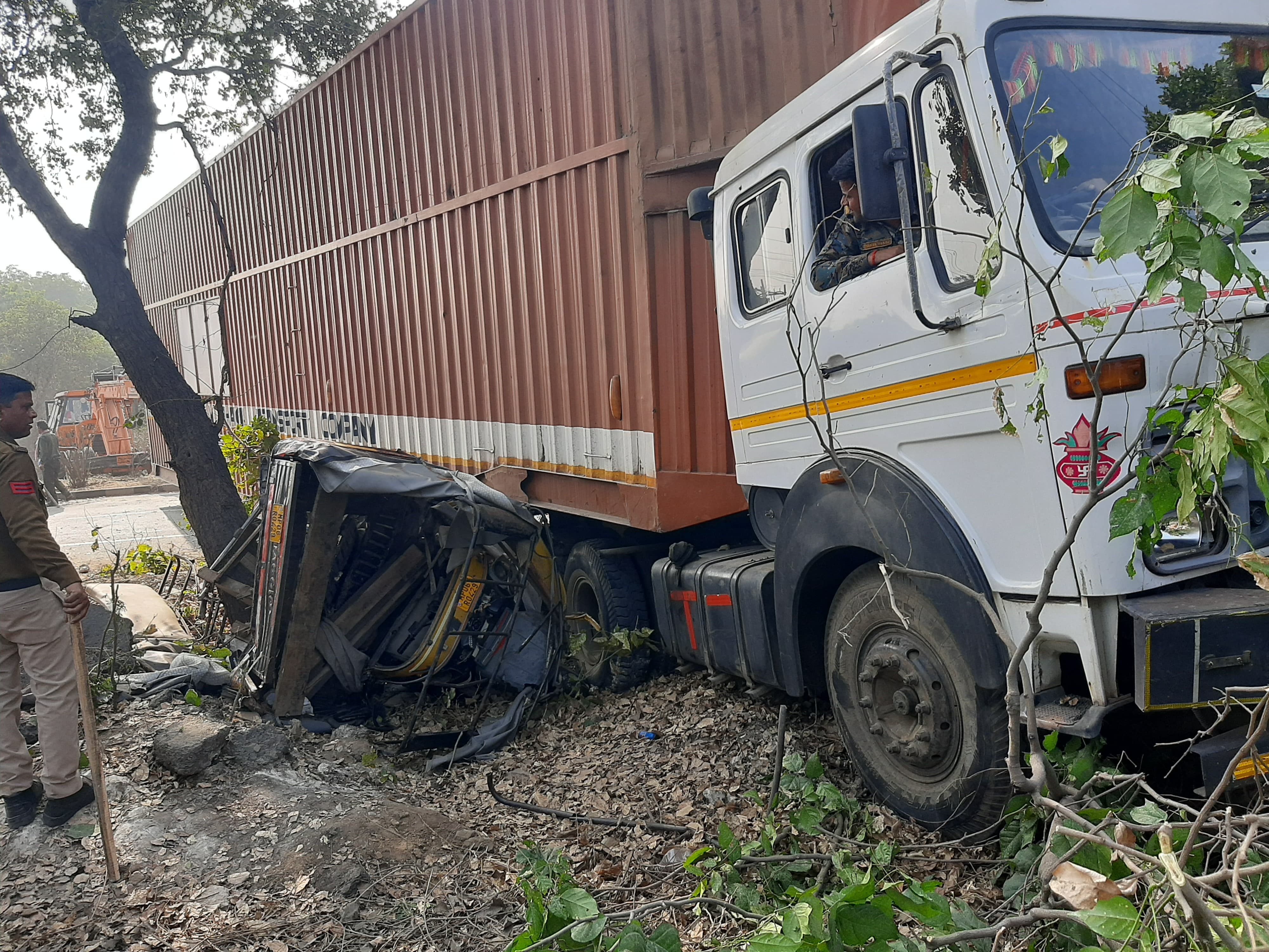 कंटेनर के नीचे फंसी टैक्सी कंटेनर के नीचे फंसी टैक्सी