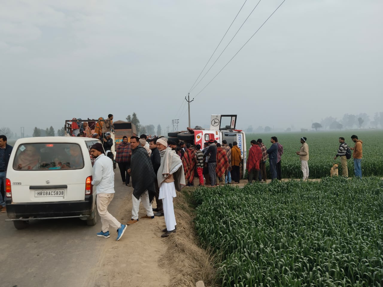 बस पलटने के बाद सवारियों की सहायता करने के लिए जमा हुए ग्रामीण बस पलटने के बाद सवारियों की सहायता करने के लिए जमा हुए ग्रामीण