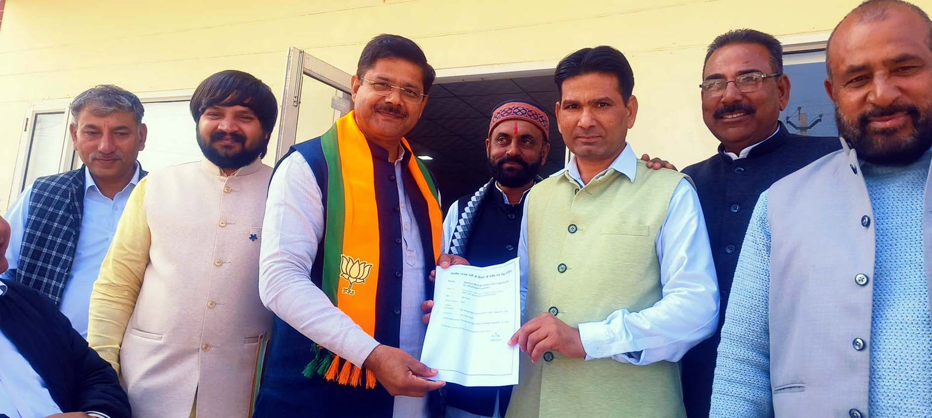 चुनाव लड़ने के इच्छुक कार्यकर्ता अपने आवेदन जिला अध्यक्ष को देते हुए।