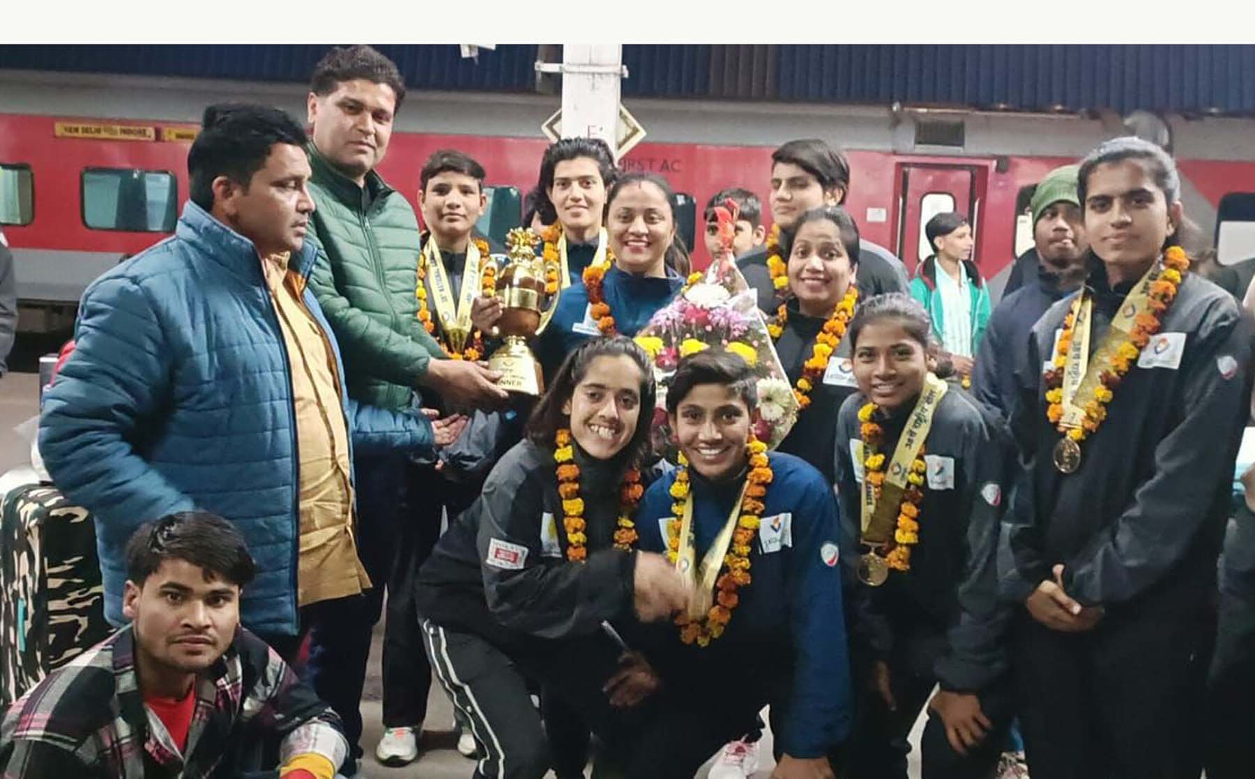 फोटो नंबर-04: पहली बार फुटबॉल में राष्ट्रीय स्तर पर पदक जीतकर लौटी हरियाणा की महिला फुटबॉल टीम का स्वागत करतेे लोग।