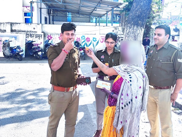 बेटी के सकुशल मिलने पर पुलिसकर्मियों को मिठाई खिलाती महिला बेटी के सकुशल मिलने पर पुलिसकर्मियों को मिठाई खिलाती महिला