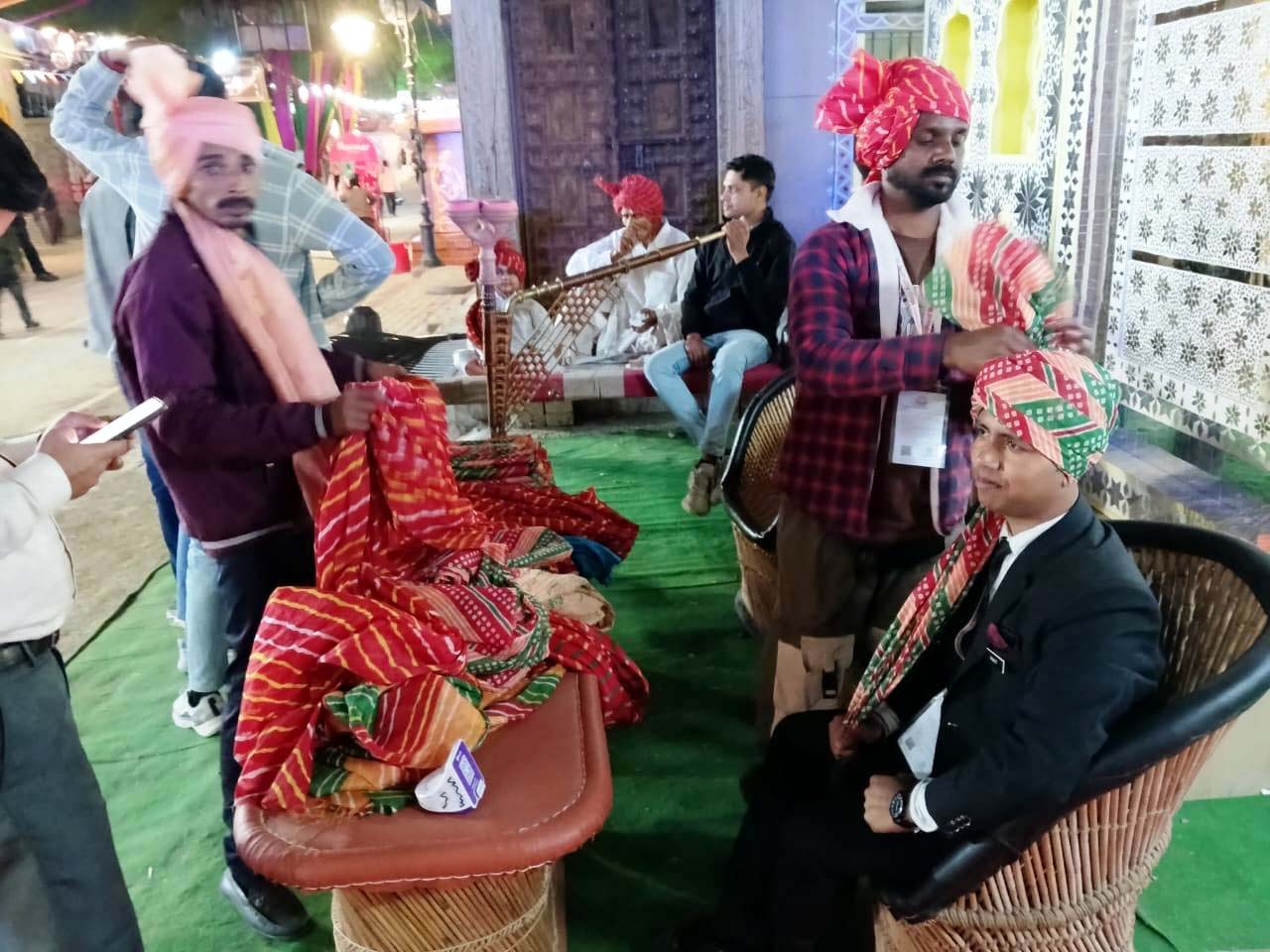 सूरजकुंड मेला परिसर में चल रही आपणा घर पवेलियन के बाहर हरियाणवी पगड़ी बंधवाते पर्यटक। सूरजकुंड मेला परिसर में चल रही आपणा घर पवेलियन के बाहर हरियाणवी पगड़ी बंधवाते पर्यटक।