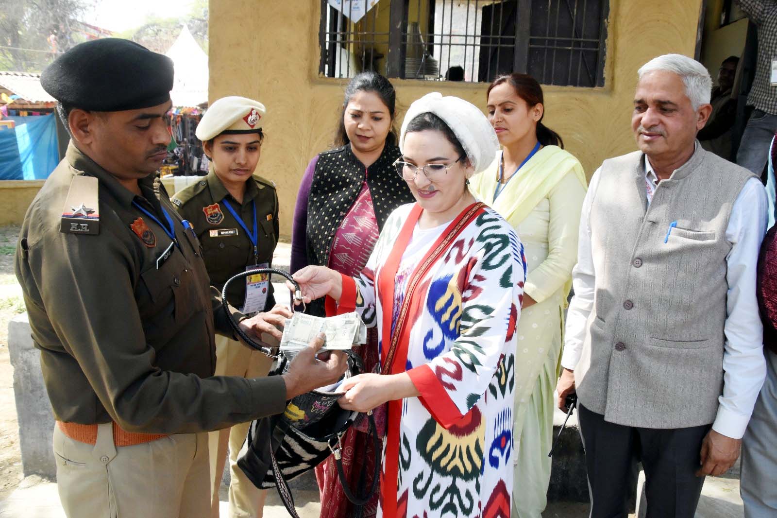 विदेशी हस्तशिल्पकार को पर्स लौटाती पुलिस विदेशी हस्तशिल्पकार को पर्स लौटाती पुलिस