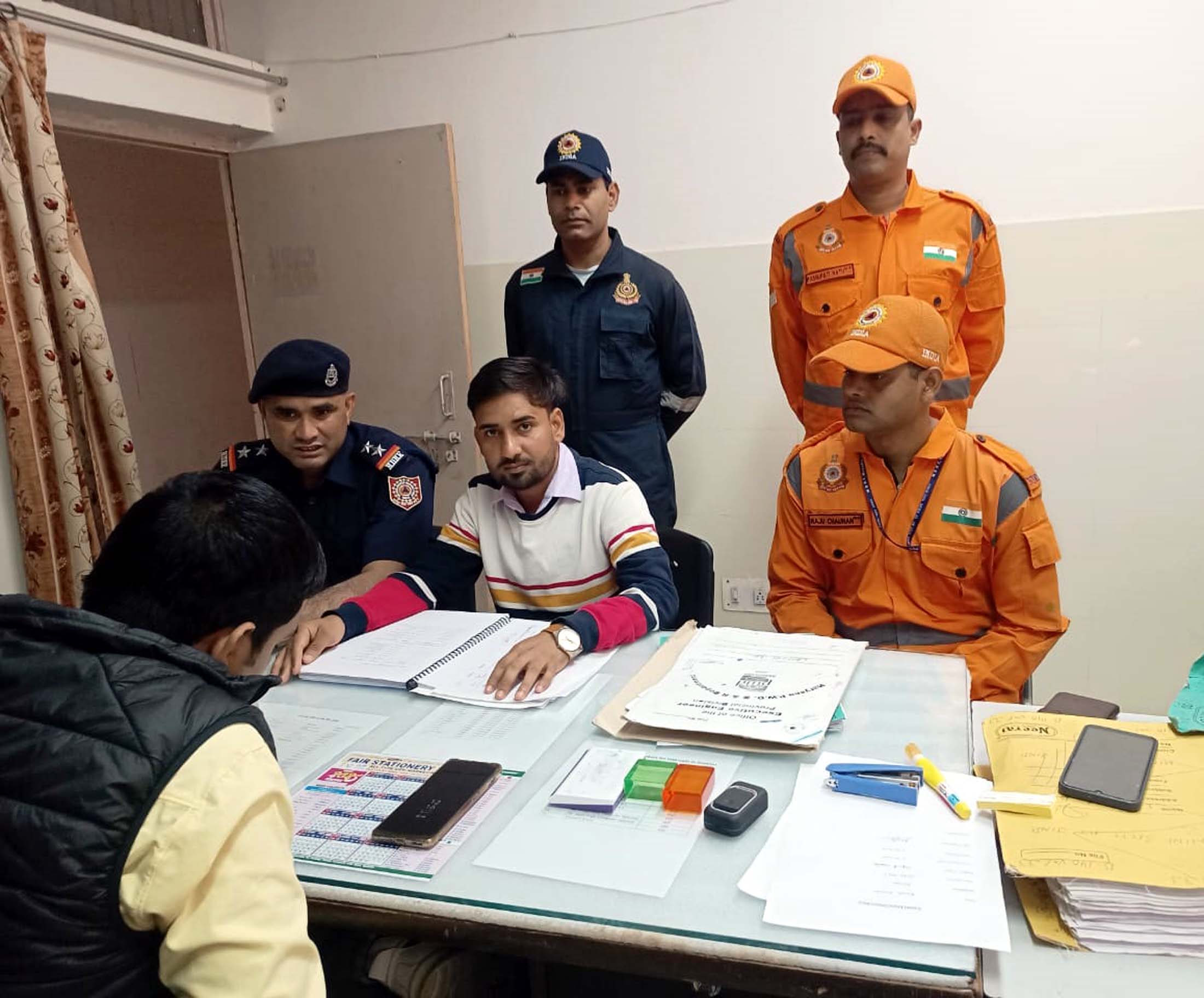 अधिकारियों से बातचीत करते हुए एनडीआरएफ टीम सदस्य।
