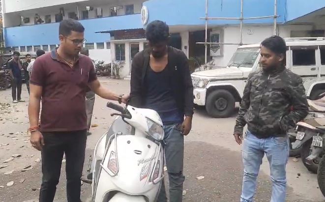 गिरफ्तार स्कूटी चोरी के साथ खड़े पुलिसकर्मी जांच करते हुए गिरफ्तार स्कूटी चोरी के साथ खड़े पुलिसकर्मी जांच करते हुए